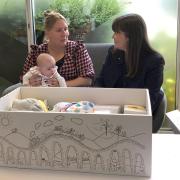 Children's minister Clare Haughey (right) meets the recipient of one baby box