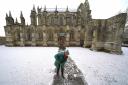 A person clears the pathway at Rosslyn Chapel in Edingburgh following a light dusting of snow.