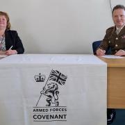 Anne MacPherson, of NHSGGC, and Major General Bill Wright sign the covenant