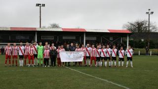 Players and match officials line up on the pitch before kick-off