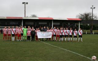 Players and match officials line up on the pitch before kick-off